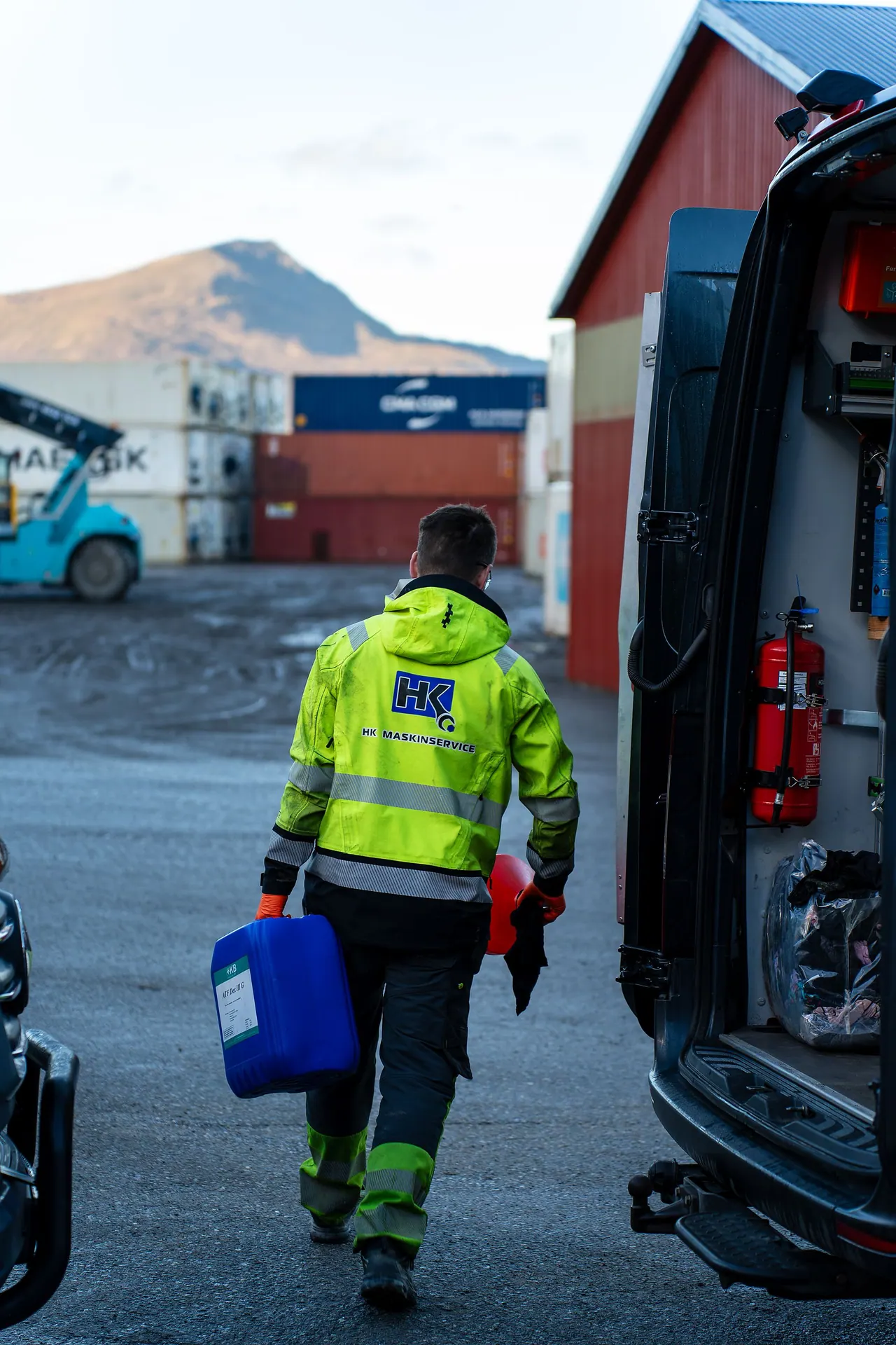 Tekniker med utstyr foran HK Maskinservice servicebil